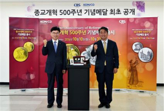 6일 종교개혁 500주년 기념메달 실물 공개 행사 후 한용길 CBS 사장(사진  오른쪽), 김화동 한국조폐공사 사장이 기념메달 실물과 함께 포즈를 취하고 있다. 사진=조폐공사 제공